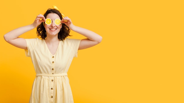 Free photo woman covering eyes with lemon slices