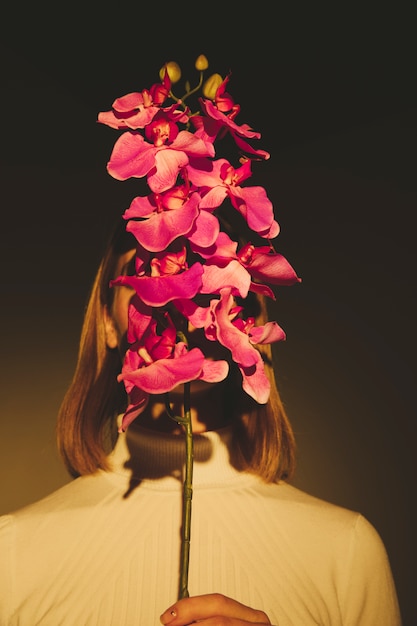 Free photo woman covering face with flower