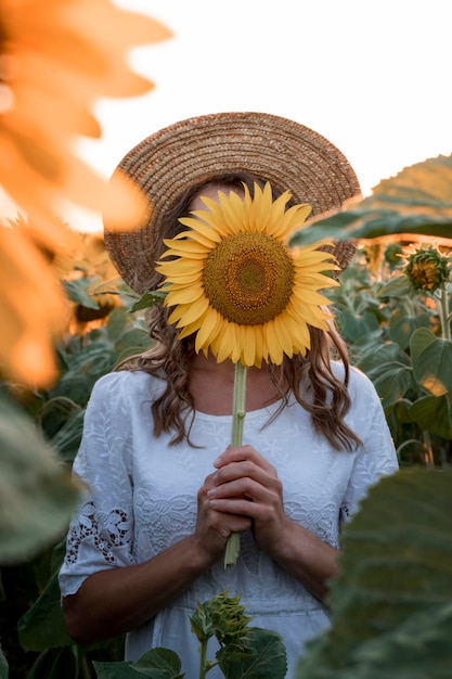 Free Photo woman covering her face with sunflower