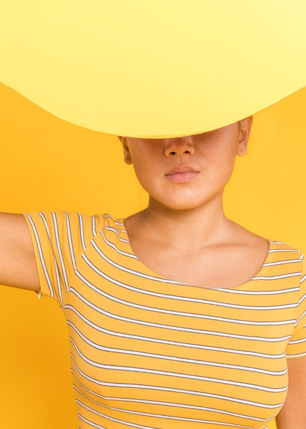 Free Photo woman covering her face with yellow card