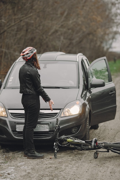 Free Photo the woman crashed into the car. girl in a helmet. people quarrel over the accident.