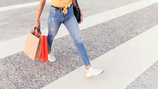 Woman crossing the street with shopping bags