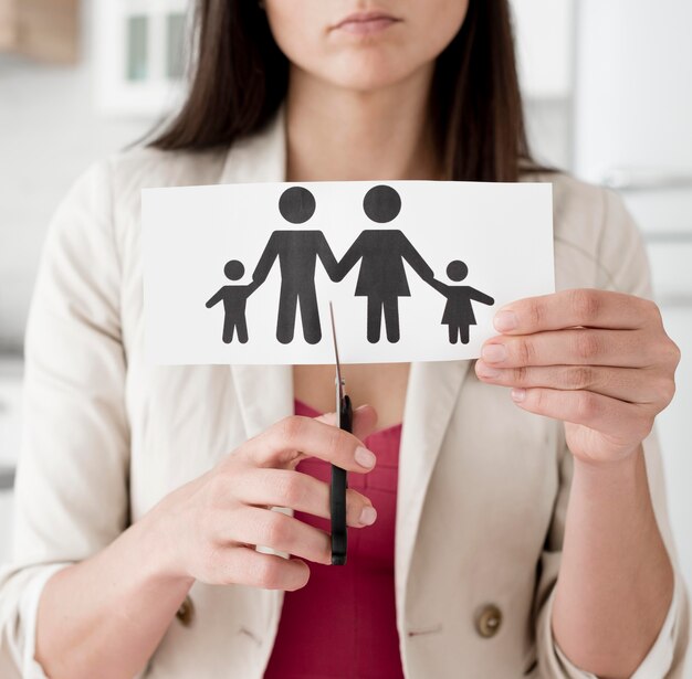 Woman cutting paper family with scissors