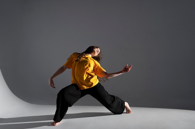 Woman dancing in studio full shot