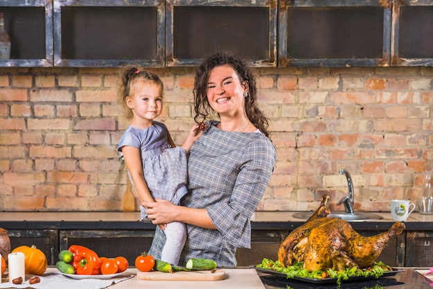 Woman and daughter at table with turkey