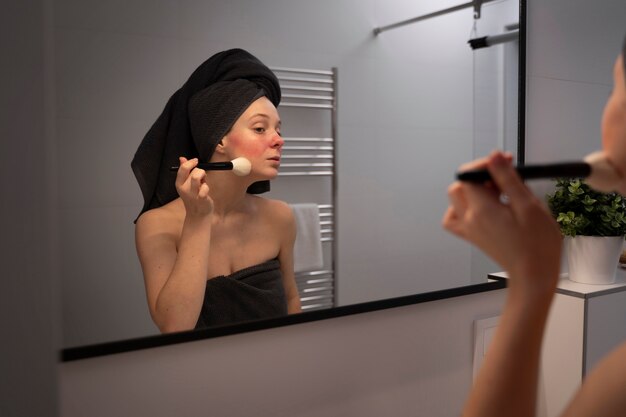 Woman dealing with rosacea applying make-up with brush