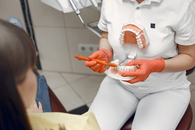 Woman in a dental chair. Dentist teaches proper care.Beauty treats her teeth