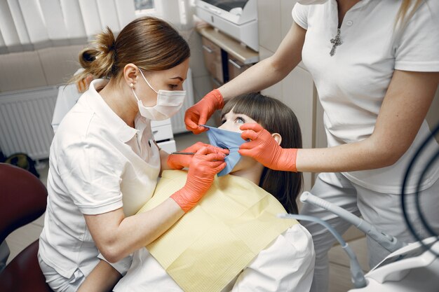 Woman in a dental chair. Girl is examined by a dentist.Dentists treat a girl's teeth