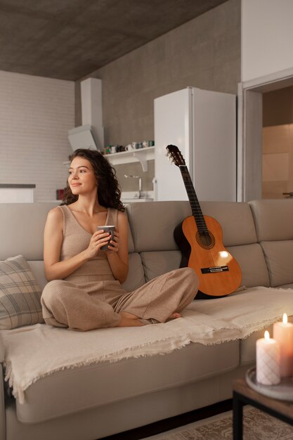 Woman digital disconnecting at home with guitar