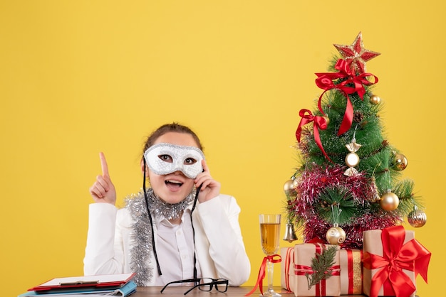 woman doctor wearing party mask on yellow