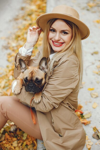 Woman and dog play and have fun in the autumn park