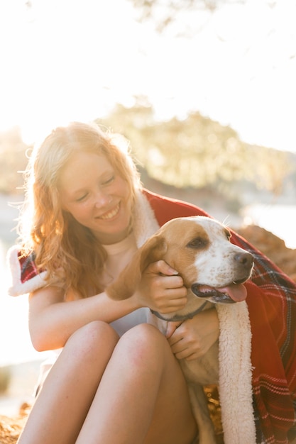 Free photo woman and dog wrapped in a blanket