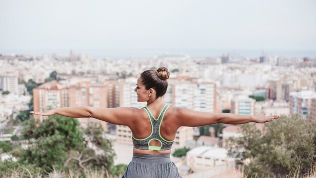 Woman doing balance exercise in front of city