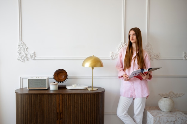 Free Photo woman doing daily activities in minimal decorated room