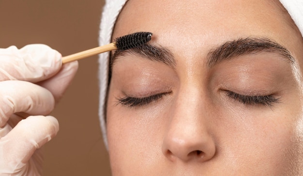 Free Photo woman doing an eyebrow treatment to her client