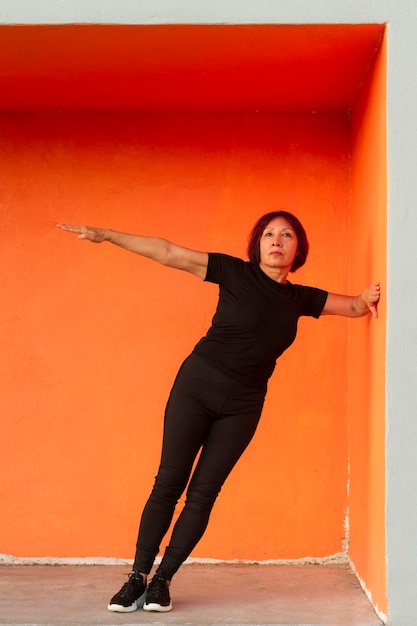 Free photo woman doing fitness exercise while leaning on a wall