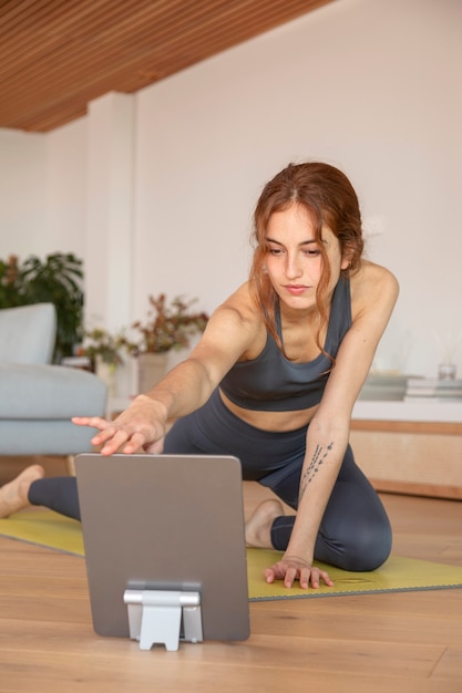 Free photo woman doing fitness at home on mat