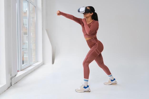 Free photo woman  doing fitness with vr glasses