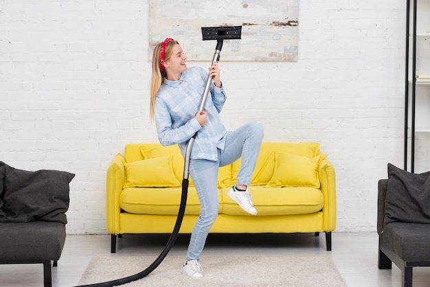 Free photo woman doing house chores with vacuum