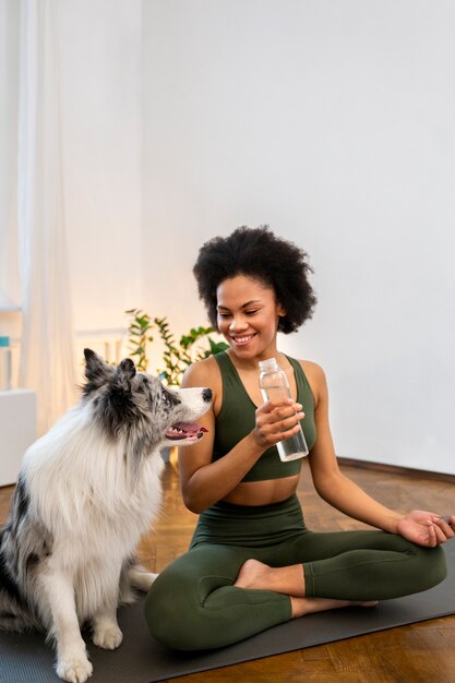 Woman doing yoga accompanied by their pet