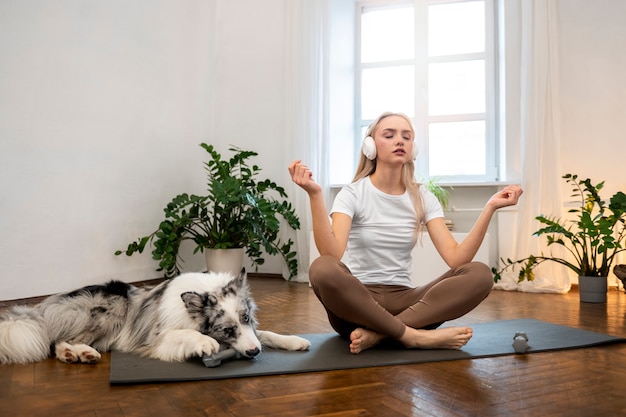 Woman doing yoga accompanied by their pet