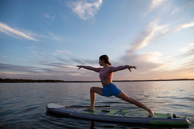 Woman doing yoga on paddleboard side view