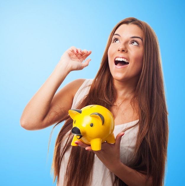 Woman dreaming and holding moneybox