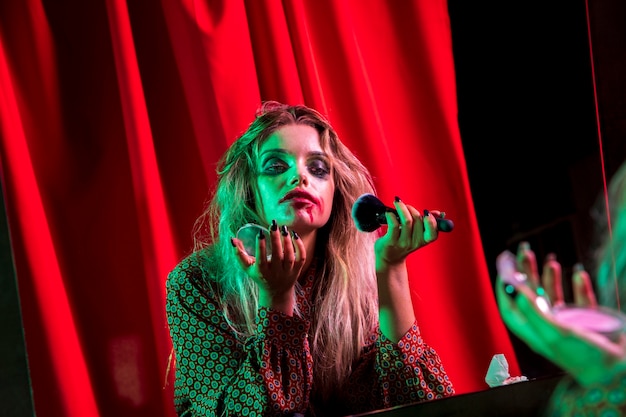 Woman dressed as a clown using a powder brush