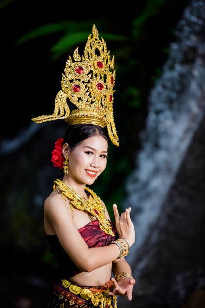 A woman dressed with an ancient Thai dress at the waterfall.