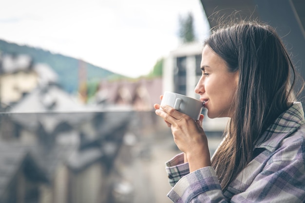 A woman drinking coffee on the balcony in the morning