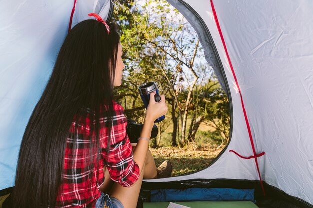 Woman drinking coffee in tent