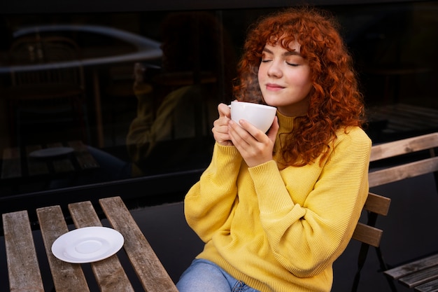 Free Photo woman drinking hot chocolate at cafe