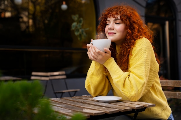 Free Photo woman drinking hot chocolate at cafe