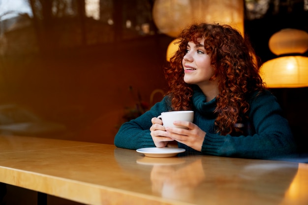 Woman drinking hot chocolate at cafe