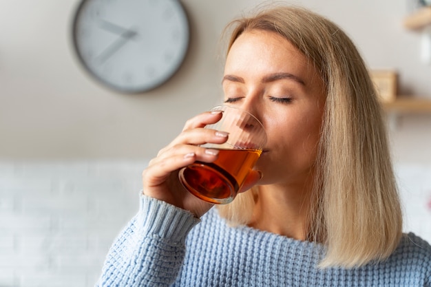 Woman drinking kombucha side view