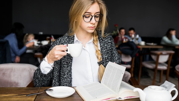 Woman drinking and reading book