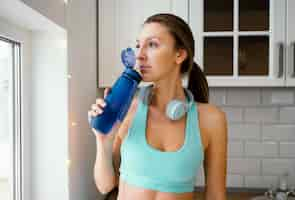 Free photo woman drinking water after workout