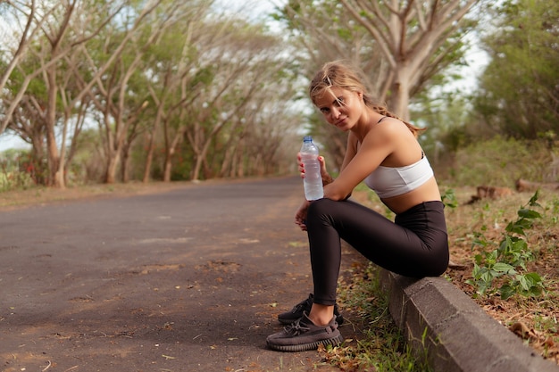 Woman drinking water in the park. bali