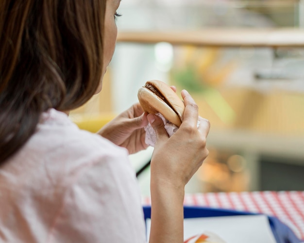 Woman eating a burger at restaurant