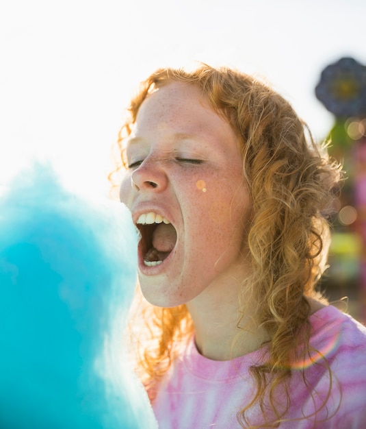 Free photo woman eating candy floss close-up