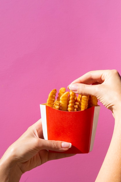 Free photo woman eating french fries from red box