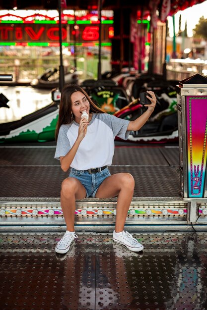 Woman eating ice cream taking selfie