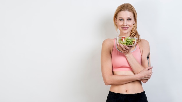 Free photo woman eating a lettuce salad