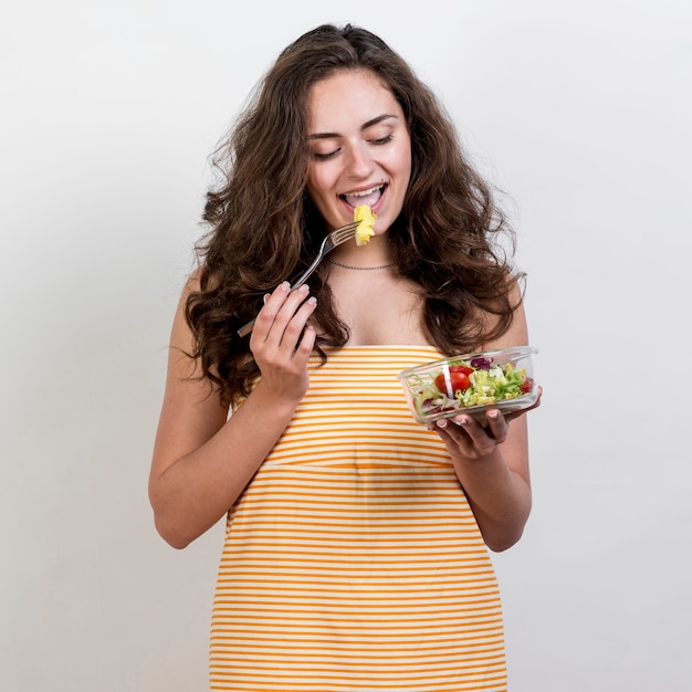 Free photo woman eating a lettuce salad