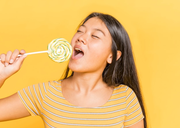 Woman eating lollipop with her eyes closed