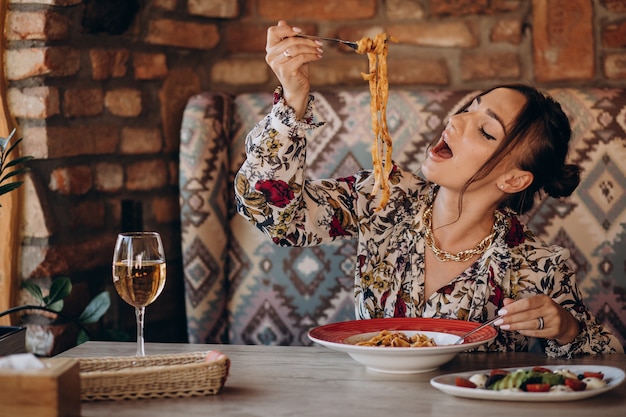 Free photo woman eating pasta in an italian restaurant