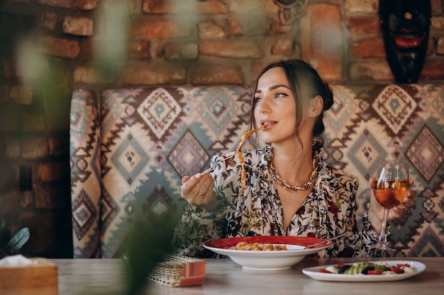 Free photo woman eating pasta in an italian restaurant