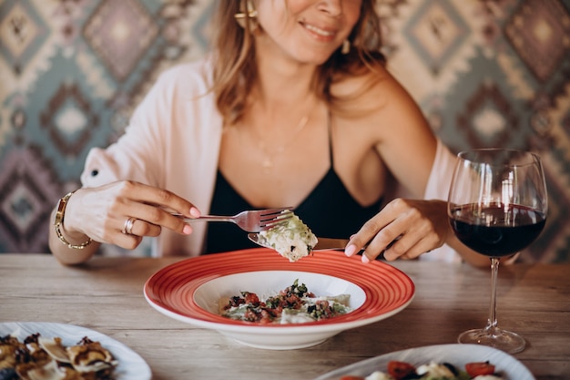 Free photo woman eating ravioli in an italian restaurant