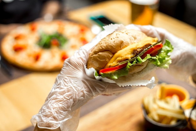 Woman eating sandwich with cheese and tomato