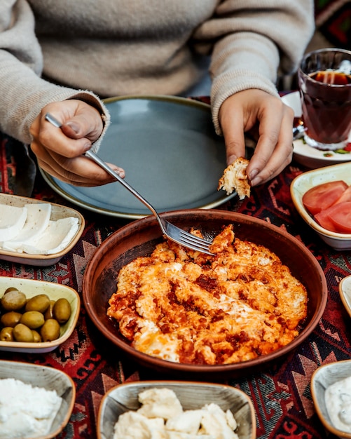 Free Photo woman eats scrambled eggs with tomatoes